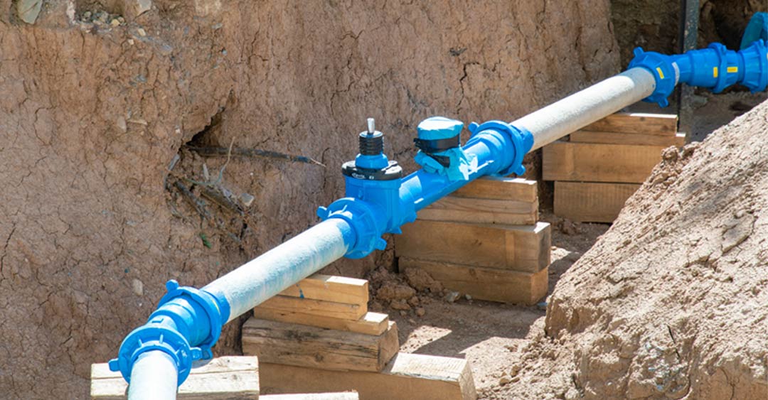 Plumbing Solutions - pipe in the dirt with blue coupling sections and angles