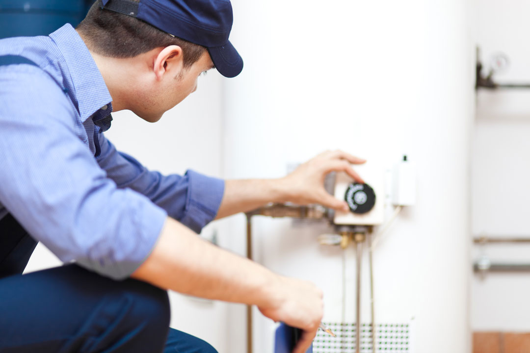 Plumbing Solutions Inc - technician inspecting water heater